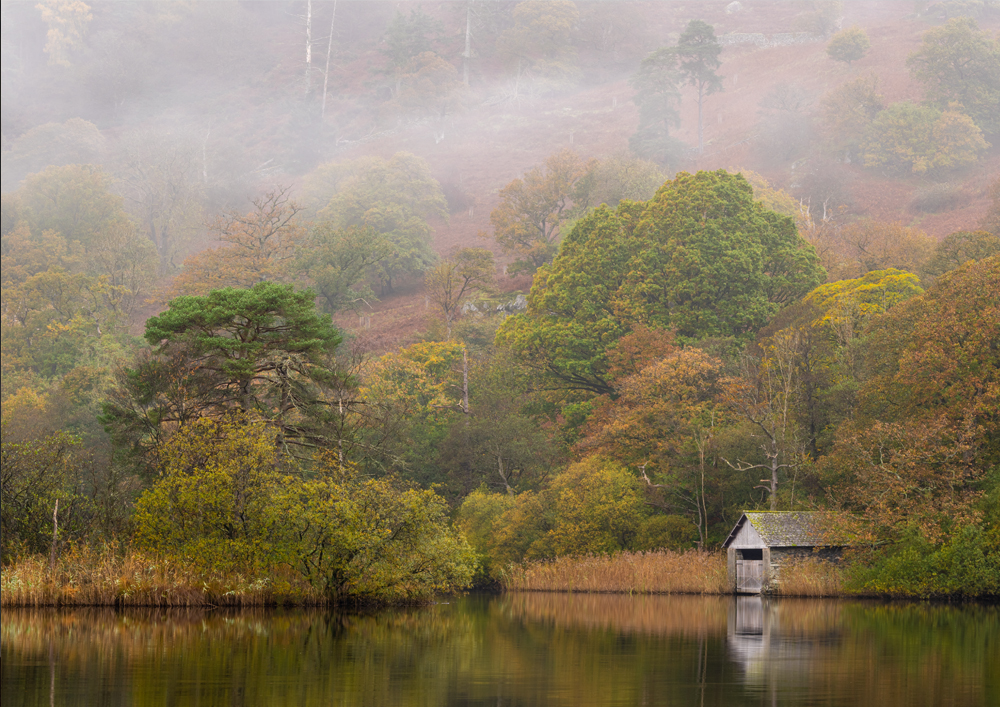 Beautiful autumnal misty photograph taken of the boat house on Rydal Water, Lake District, England.